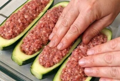 Thumbnail for Press raw ground beef inside raw hollowed zucchini halves, alongside 2 ingredients, into a glass baking dish for a fresh summer dinner that’s my default when I don’t know what to make